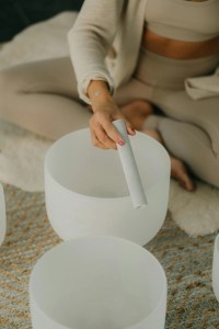 Woman playing crystal singing bowls during a sound healing session